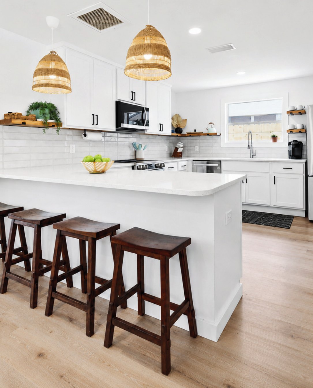 Bright coastal kitchen with woven pendant lighting and counter seating