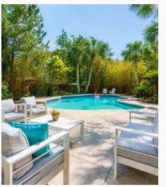 Screened pool and patio surrounded by tropical planting